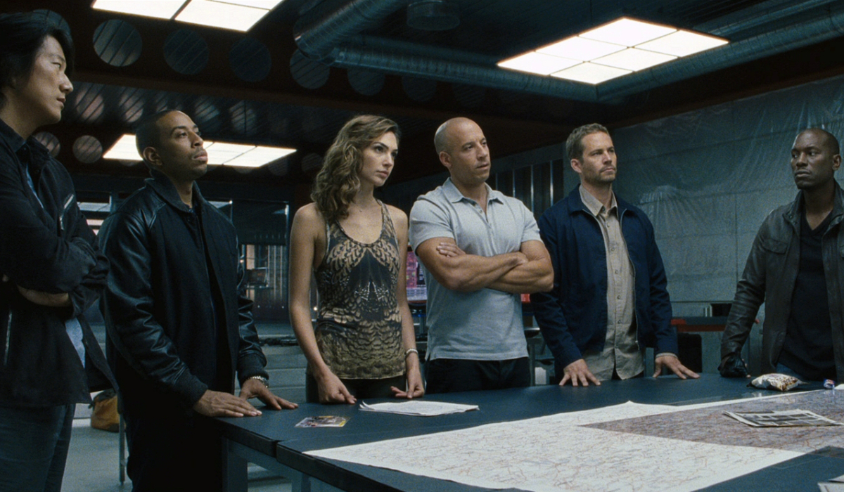 Fast & Furious 6 the crew standing around a table with plans