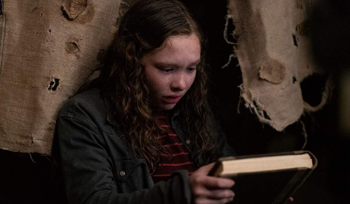 Scary Stories To Tell In The Dark Stella holds the book while hiding in the Bellows house