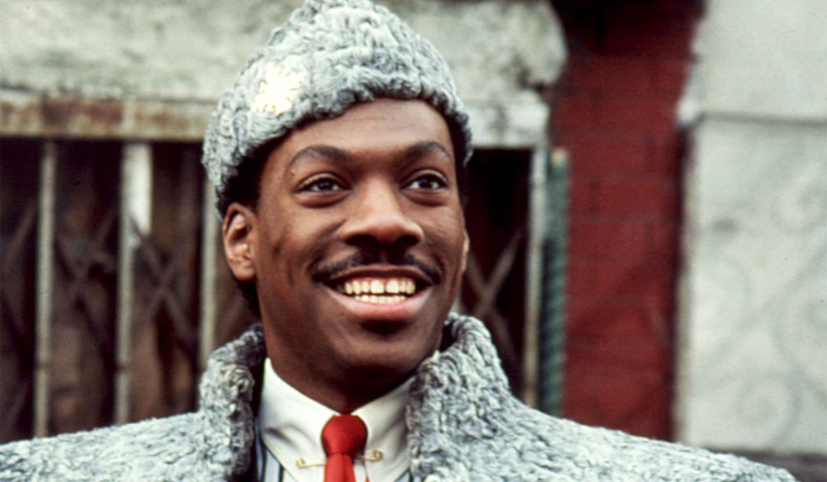 Coming To America Prince Akeem smiling in front of a New York building