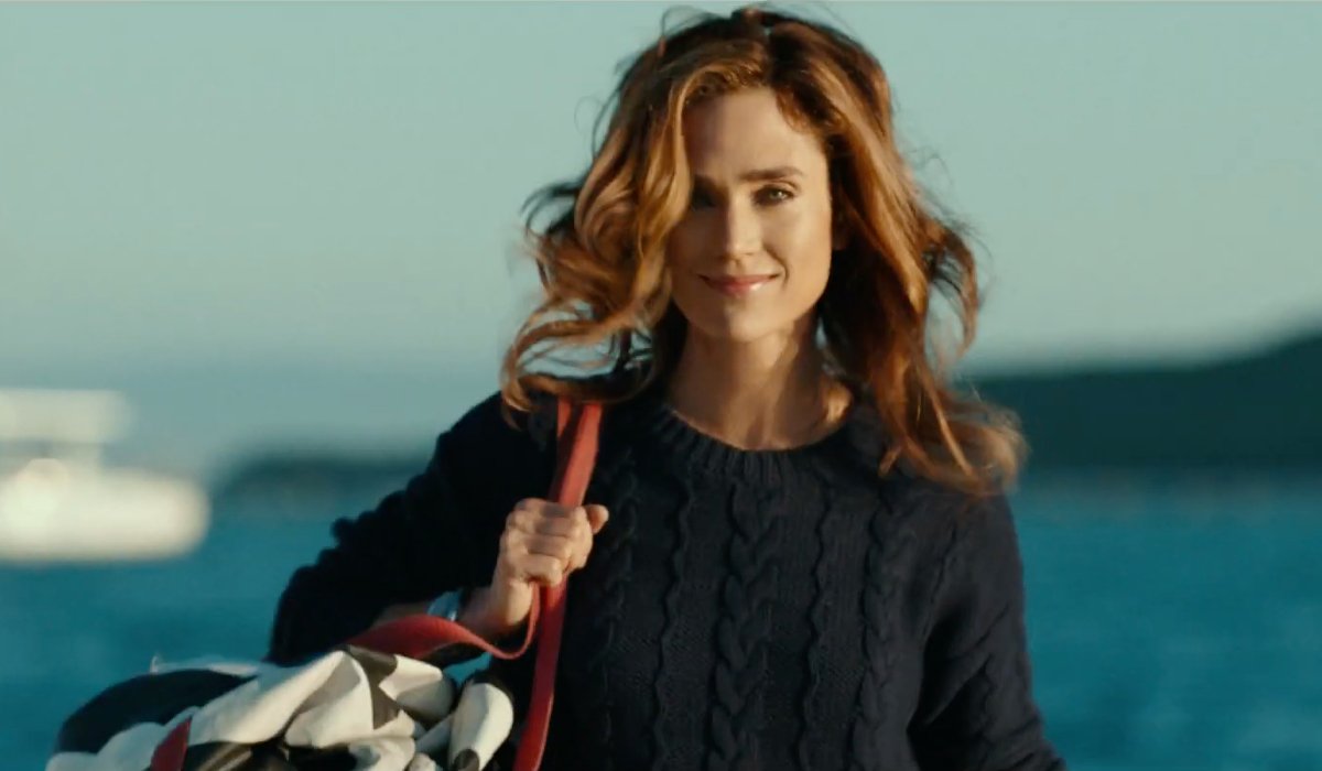 Top Gun: Maverick Jennifer Connelly carrying a bag and smiling on the beach