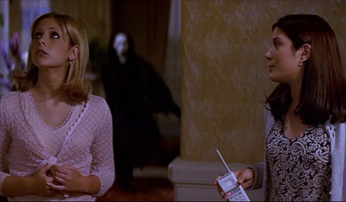Scream 2 Ghostface sneaks up behind Sarah Michelle Gellar and her friend