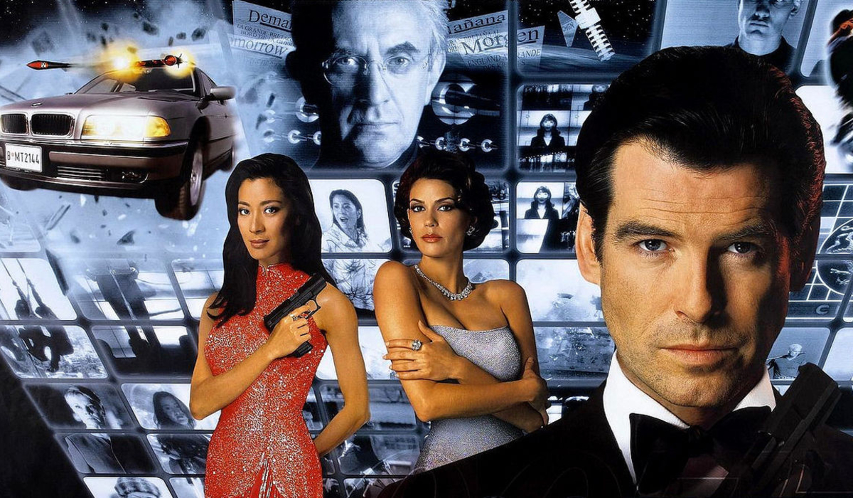 Tomorrow Never Dies Bond and his co-stars in front of a wall of monitors
