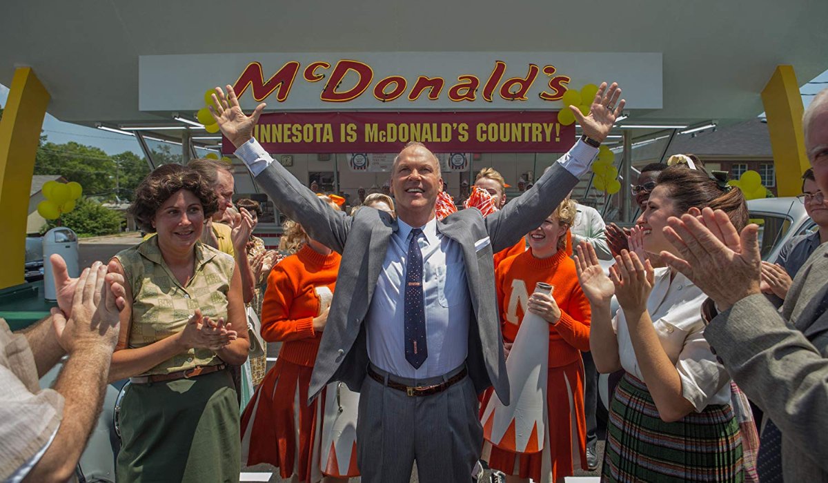 The Founder Michael Keaton raises his hands in celebration at a McDonalds