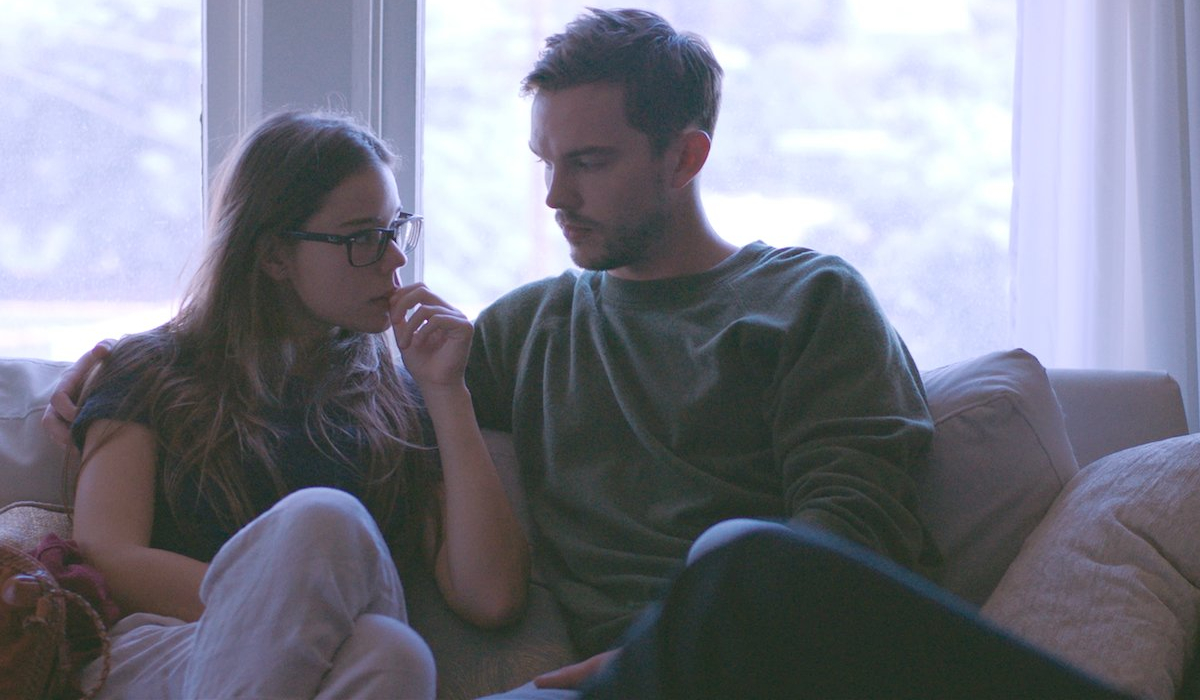 Newness Laia Costa and Nicholas Hoult stare at each other on the couch